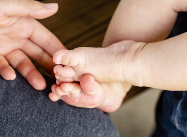 küçük bebeğin bacakları ve annesinin el geçti içinde dışarıda