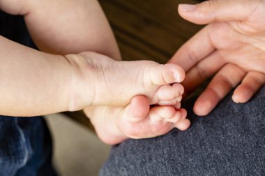 küçük bebeğin bacakları ve annesinin el geçti içinde dışarıda