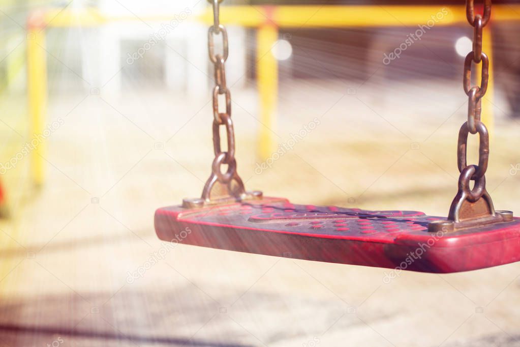 red swing hanging isolate on modern kids playground.close up.