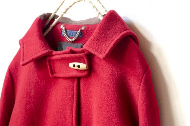 kırmızı yün ceket elbise askısı beyaz arka plan üzerinde asılı. Yakın çekim