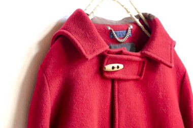 kırmızı yün ceket elbise askısı beyaz arka plan üzerinde asılı. Yakın çekim