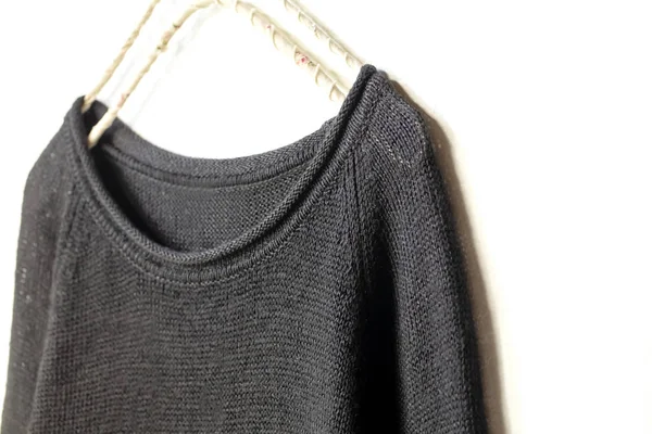 黒のセーターまたはカットを縫う白 Background Close にハンガーに掛かっています — ストック写真