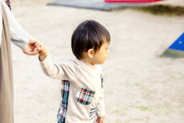 bir çocuk üzerinde açık havada annesinin el çekerek.