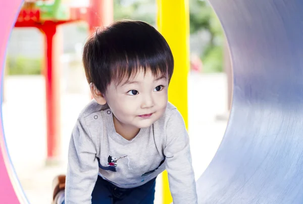 Junge, Kind oder Kind spielen im Tunnel auf Spielplatz. — Stockfoto