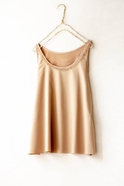 Turuncu bej beyaz bir duvar bir askı asılı atlet.