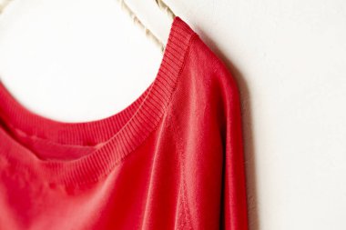 bir kesim sew veya örgü içinde kırmızı beyaz arka plan üzerinde elbise askısı üzerinde asılı.