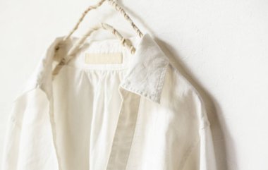 bir bluz ya da gömlek elbise askısı beyaz arka plan üzerinde beyaz asılı olarak. Yakın çekim.