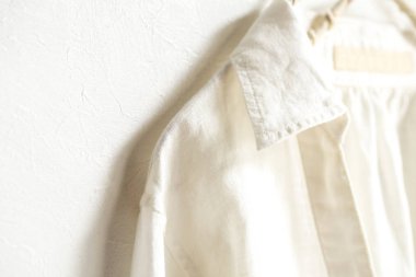 bir bluz ya da gömlek elbise askısı beyaz arka plan üzerinde beyaz asılı olarak. Yakın çekim.