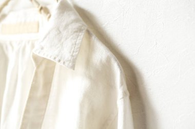 bir bluz ya da gömlek elbise askısı beyaz arka plan üzerinde beyaz asılı olarak. Yakın çekim.