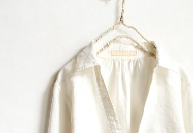 bir bluz ya da gömlek elbise askısı beyaz arka plan üzerinde beyaz asılı olarak. Yakın çekim.