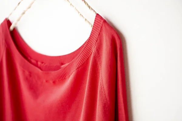 A cut sew or knit in red hanging on clothes hanger on white background. — Stock Photo, Image