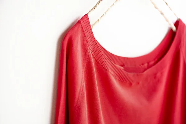 A cut sew or knit in red hanging on clothes hanger on white background. — Stock Photo, Image