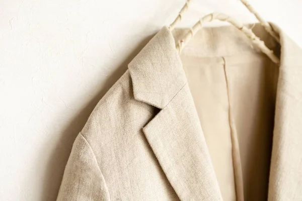 Chaqueta beige del cuero real colgando en la percha de ropa sobre fondo blanco . — Foto de Stock