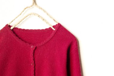 beyaz arka plan üzerinde giysi askısı asılı kırmızı bir hırka.