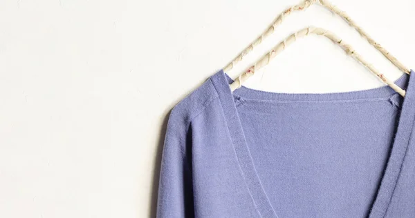 Blue wool sweater hanging on clothes hanger on white background — Stock Photo, Image