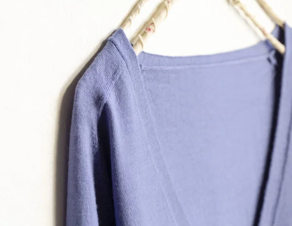 Blue wool sweater hanging on clothes hanger on white background — Stock Photo, Image