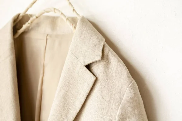 Chaqueta beige del cuero real colgando en la percha de ropa sobre fondo blanco . — Foto de Stock