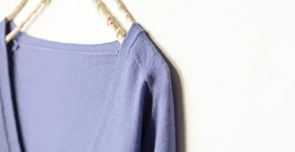 Suéter de lana azul colgando de la percha de ropa sobre fondo blanco — Foto de Stock