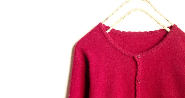 A cardigan in red hanging on clothes hanger on white background. — Stock Photo, Image
