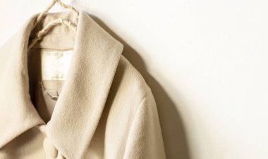 bej yün ceket beyaz arka plan üzerinde giysi askısı asılı
