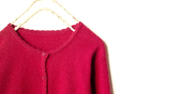 A cardigan in red hanging on clothes hanger on white background. — Stock Photo, Image