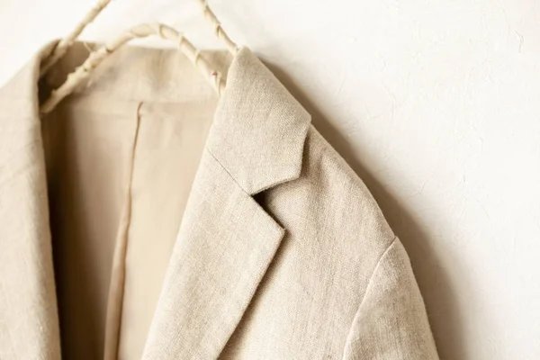 Chaqueta beige del cuero real colgando en la percha de ropa sobre fondo blanco . — Foto de Stock