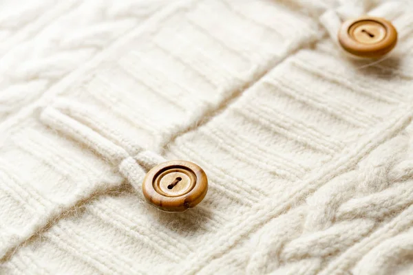 Hintergrund Textur aus weißem Muster Strickstoff aus Baumwolle oder Wolle und Holzknopf. — Stockfoto