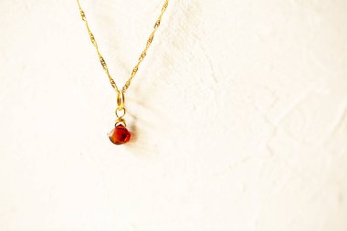 golden necklace with the stone of the chestnut brown on white background. clipart