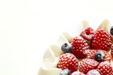 Beyaz arka plan üzerinde izole çilek ve yaban mersini taze kremalı pasta.