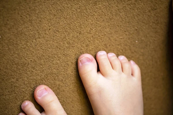 I piedi nudi dei bambini. Piedi nudi del bambino su sfondo marrone . — Foto Stock