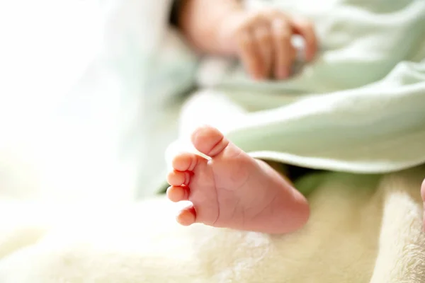 Newborn baby on a white and light blue blanket - tiny baby feet. — Stock Photo, Image