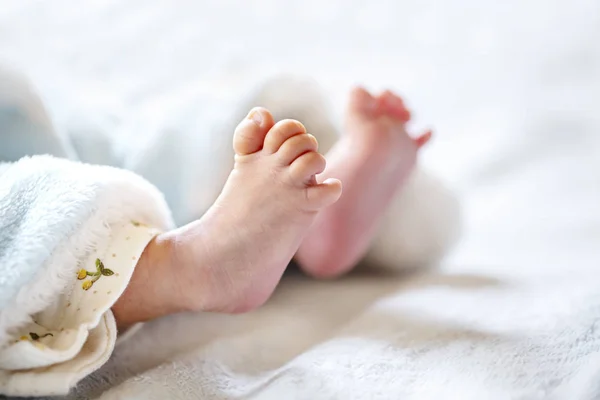 白と水色の毛布の上の新生児 - 小さな赤ちゃんの足. — ストック写真