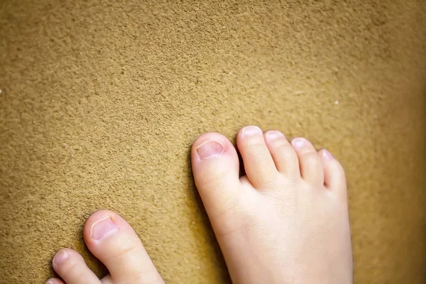 Les pieds nus des enfants. Les pieds nus de l'enfant sur fond brun . — Photo