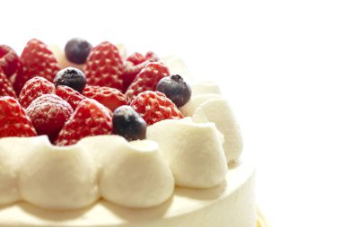 Beyaz arka plan üzerinde izole çilek ve yaban mersini taze kremalı pasta.