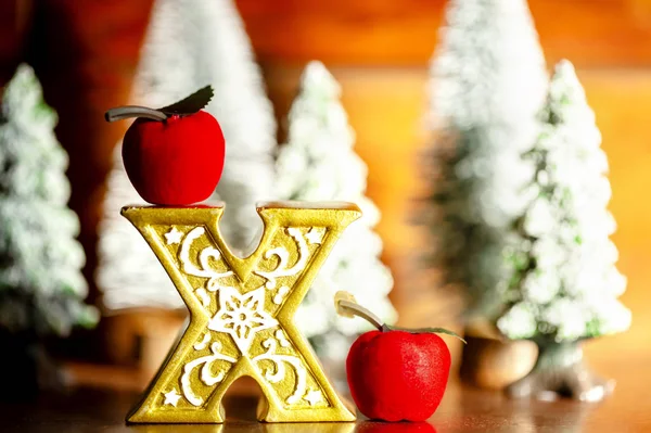 Mini julgranar med x av guldet med äpple i skogen. Bokeh ljus med trä bakgrund. — Stockfoto