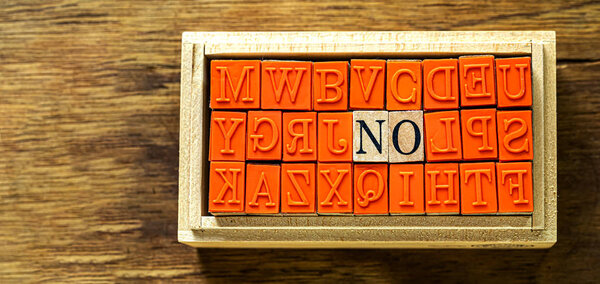 NO - isolated abstract in wood type stamps against wooden background and copy space.