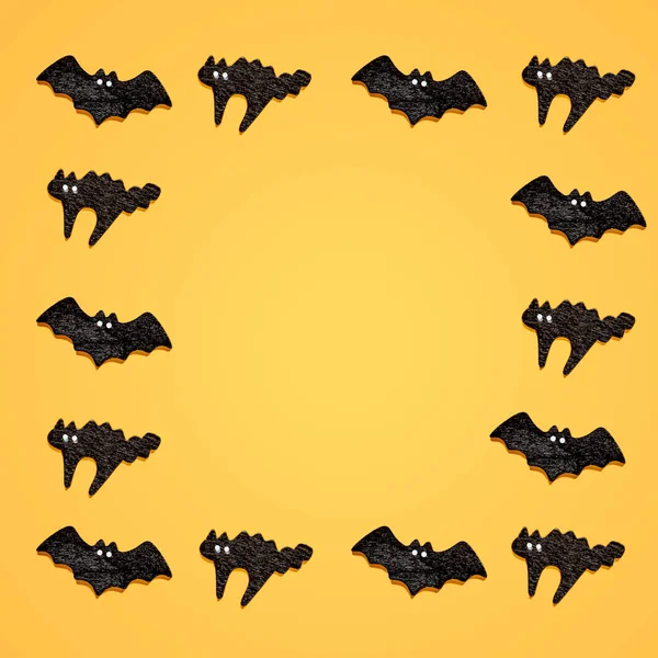 一组黑色蝙蝠与猫隔离在橙色背景。万圣节饰品是五颜六色的色调. — 图库照片