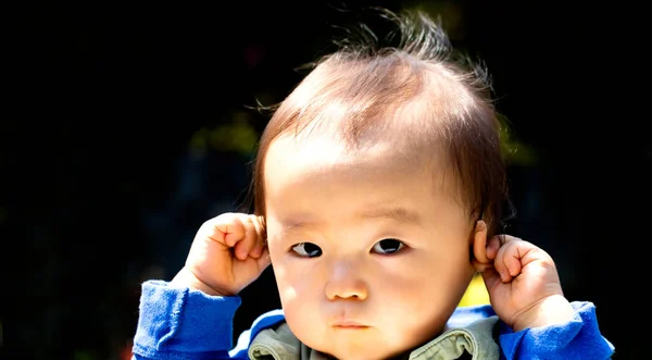 Bebé Tocándose Las Orejas Aisladas Sobre Fondo Negro Copiando Espacio —  Fotos de Stock