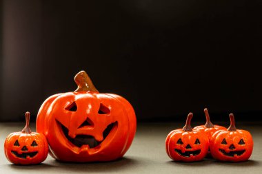 Küçük gülümseme portakalları ve siyah arka planda büyük bir gülümseme balkabağı kopyalama alanı.