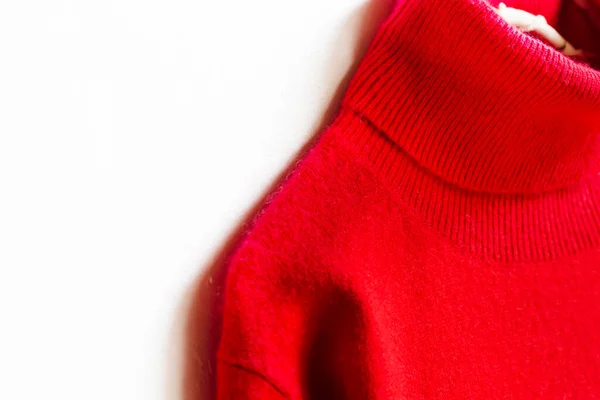 Roter Wollpullover Der Einem Kleiderbügel Auf Weißem Hintergrund Hängt Nahaufnahme lizenzfreie Stockbilder