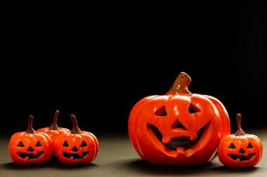 Küçük gülümseme portakalları ve siyah arka planda büyük bir gülümseme balkabağı kopyalama alanı.