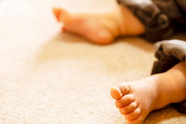 Küçük bebek yerde oturuyordu. feet 'i kapat ve boşluğu kopyala.