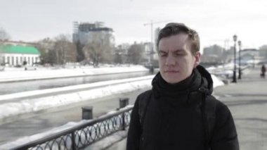 Sırt çantası ile genç adam şehirde tahta üzerinde yürür.