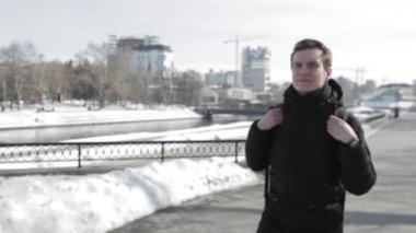 Sırt çantası ile genç adam şehirde tahta üzerinde yürür.