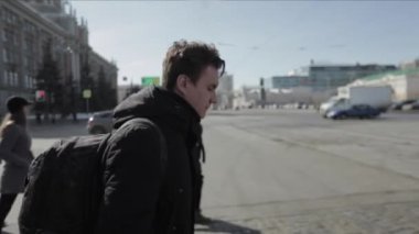 Adam sokakta yaya geçidi aracılığıyla haçlar. adam acele siyah bir çanta ile çalışmak ve çalışma.