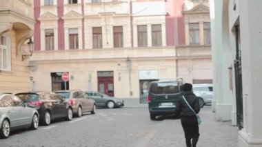 genç çekici turist kız siyah postunda eski şehir etrafında yürür. Avrupa'nın langmarks bakarak genç kadın bilgisiyle