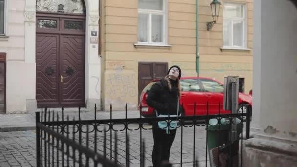 Jonge aantrekkelijke toeristische meisje in zwarte kleding loopt rond de oude stad. Jonge vrouwelijke touri kijken naar langmarks in Europa — Stockvideo