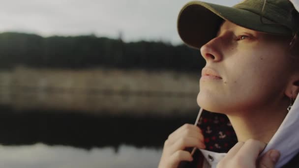 Portrait jeune belle femme dans une capuche dans un chapeau, bateau sur le lac — Video