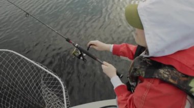 Bir tekne içinde kız gölde balık tutuyor. Vahşi doğanın ısmarlayarak.