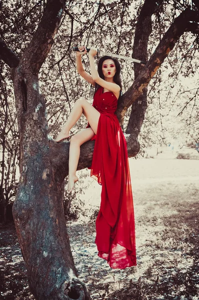 Asian Kobieta Pięknej Czerwonej Sukience Siedzi Drzewie — Zdjęcie stockowe